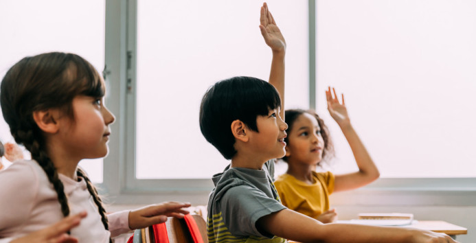 hands raised in classroom 943x481