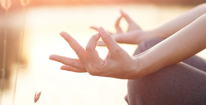 Woman meditating by the lake